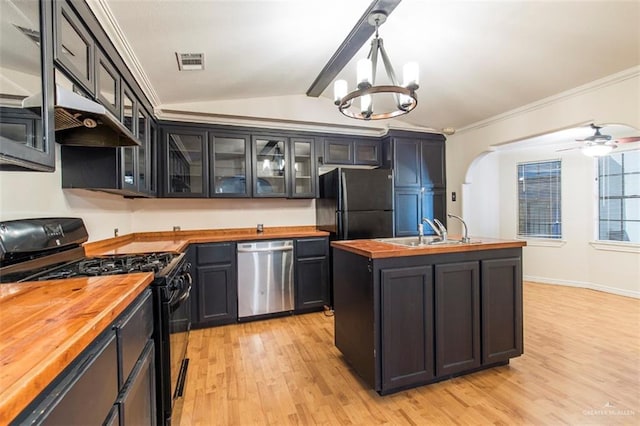 kitchen featuring sink, vaulted ceiling with beams, wooden counters, hanging light fixtures, and black appliances