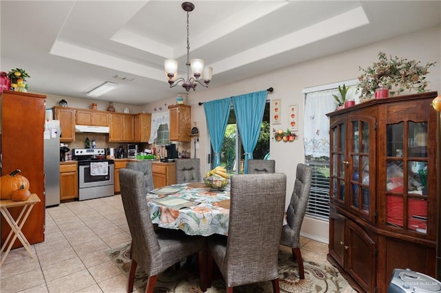 dining space featuring light tile patterned floors, visible vents, a raised ceiling, and a chandelier