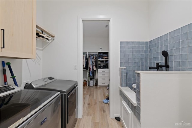 5112 W Burberry St, Edinburg, TX 78541 - washroom featuring cabinet space, washing machine and dryer, and light wood finished floors