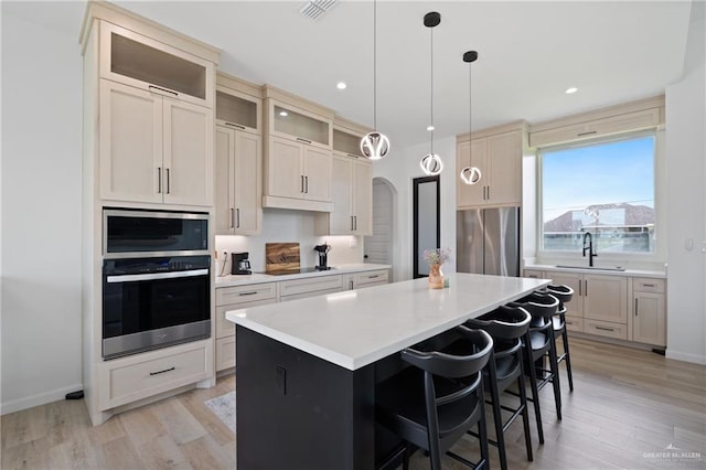 5112 W Burberry St, Edinburg, TX 78541 - kitchen with appliances with stainless steel finishes, light wood finished floors, a kitchen island, light countertops, and recessed lighting