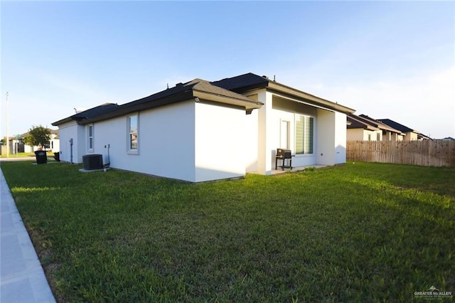 view of property exterior featuring central AC and a yard