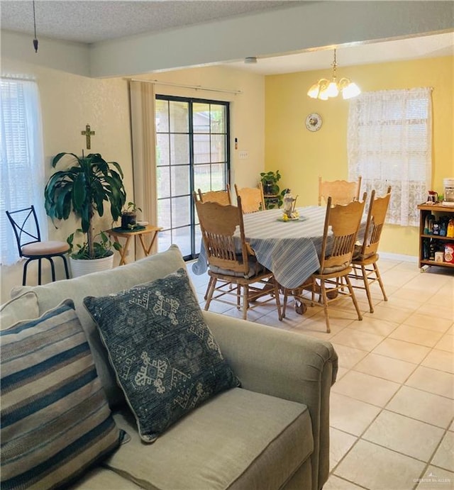 dining space with a textured ceiling, light tile patterned flooring, and a chandelier