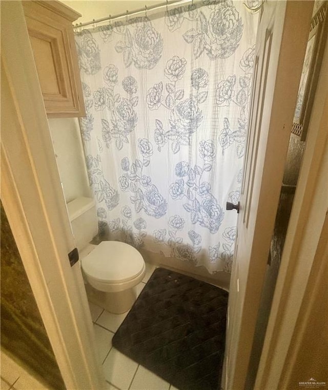 full bathroom with toilet, tile patterned floors, and a shower with curtain