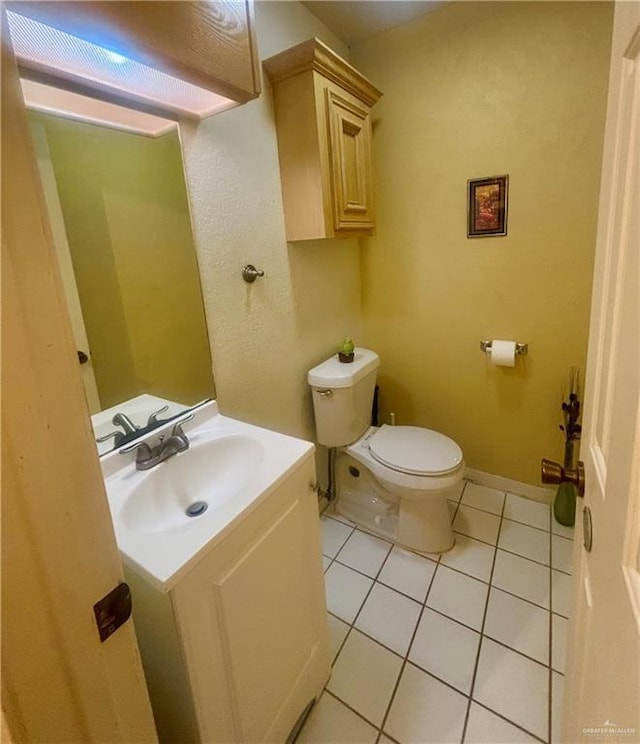 bathroom featuring vanity, tile patterned flooring, and toilet