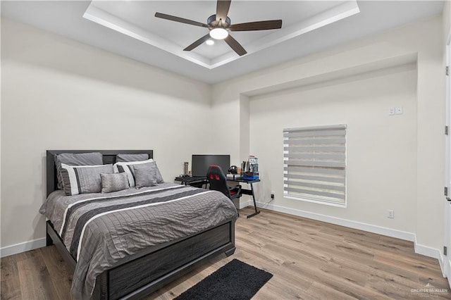 1620 Stonegate Dr, Mission, TX 78574 - bedroom featuring a raised ceiling, wood finished floors, baseboards, ceiling fan, and an office area