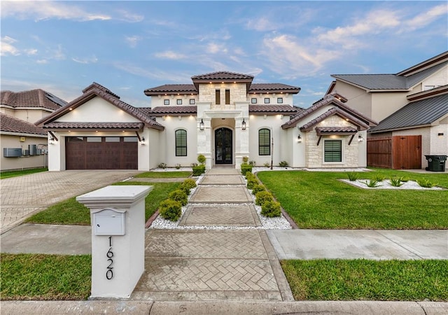 1620 Stonegate Dr, Mission, TX 78574 - mediterranean / spanish-style house with stucco siding, a garage, driveway, a tile roof, and stone siding