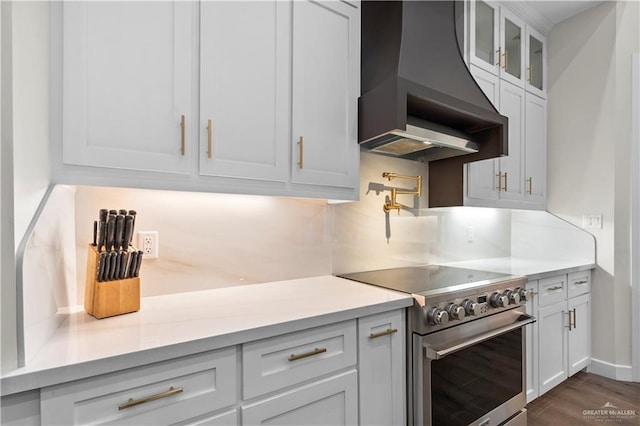 1620 Stonegate Dr, Mission, TX 78574 - kitchen with high end stainless steel range, premium range hood, light countertops, glass insert cabinets, and dark wood-type flooring