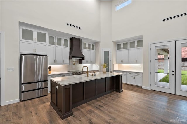 1620 Stonegate Dr, Mission, TX 78574 - kitchen with freestanding refrigerator, custom range hood, a high ceiling, a sink, and white cabinetry