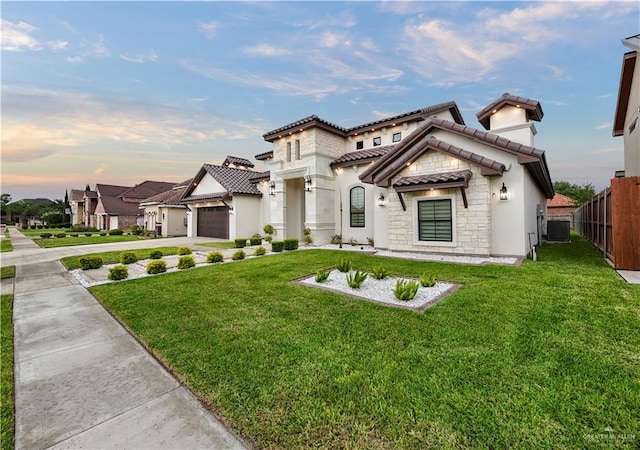 1620 Stonegate Dr, Mission, TX 78574 - mediterranean / spanish home with stone siding, a tile roof, driveway, a garage, and central air condition unit