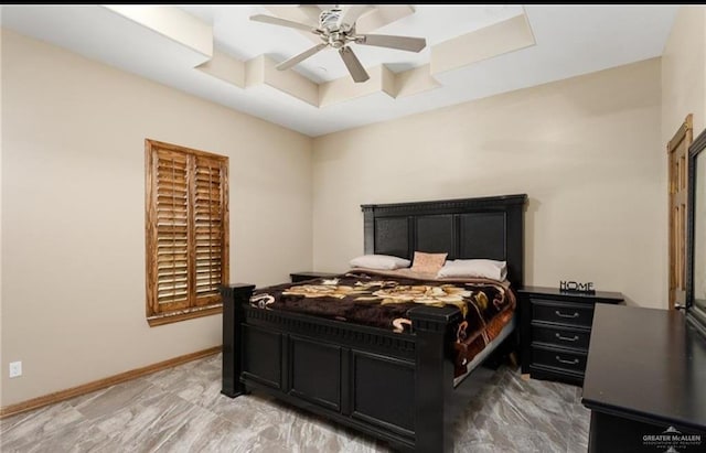 bedroom featuring ceiling fan and a tray ceiling