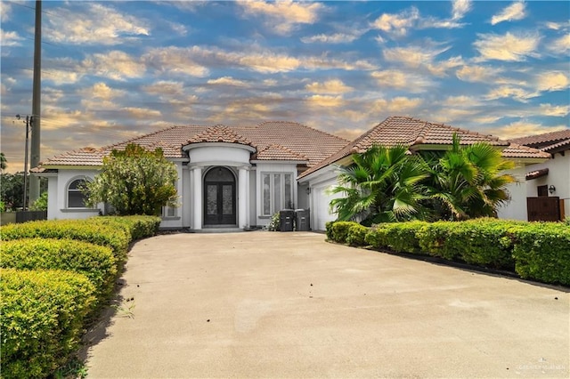 mediterranean / spanish-style home featuring a garage and french doors