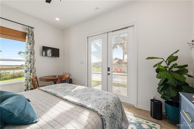 bedroom featuring ceiling fan, light wood-type flooring, access to outside, and multiple windows