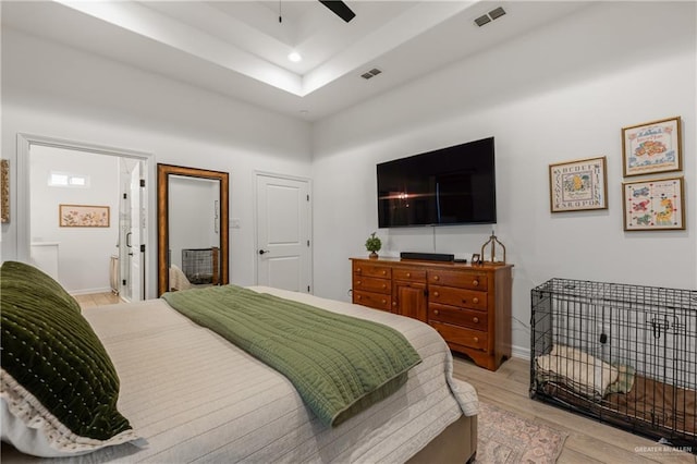 bedroom with connected bathroom, ceiling fan, and light wood-type flooring