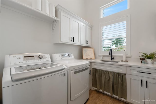 laundry area with washer and dryer, dark hardwood / wood-style flooring, cabinets, and sink