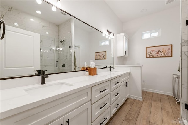 bathroom featuring wood-type flooring, vanity, and a shower with door