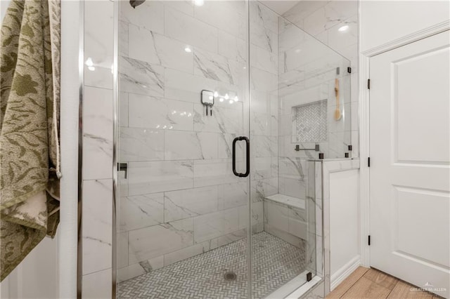 bathroom with hardwood / wood-style floors and an enclosed shower