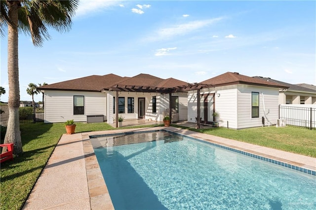 rear view of house with a pergola, a lawn, a patio, and a fenced in pool