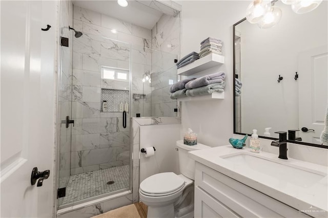 bathroom with vanity, toilet, and a shower with door