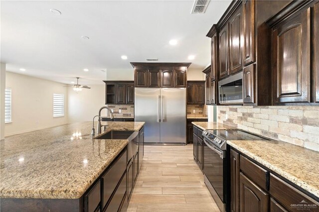 7303 Umar Ave, Mission, TX 78573 - kitchen featuring appliances with stainless steel finishes, recessed lighting, a sink, dark brown cabinetry, and decorative backsplash
