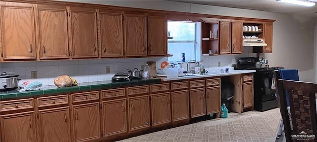 5906 N Brushline Rd, Mission, TX 78574 - kitchen with gas stove, open shelves, under cabinet range hood, tile countertops, and a sink