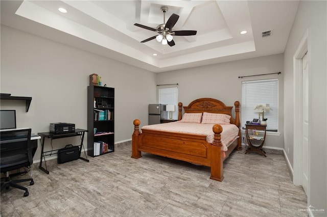 bedroom with a raised ceiling and ceiling fan