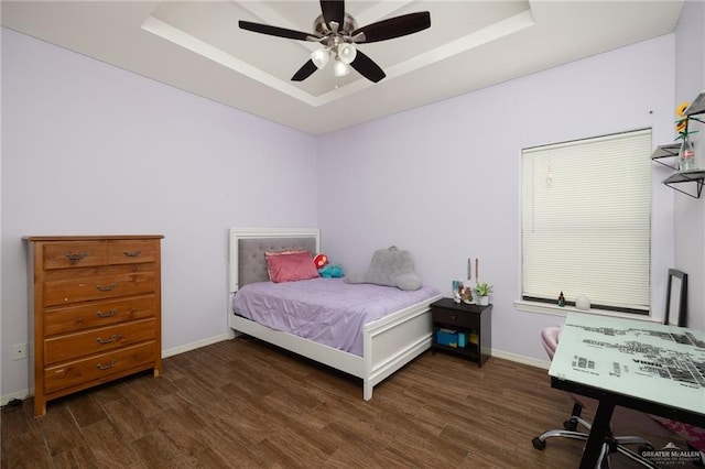 bedroom featuring a tray ceiling, ceiling fan, and dark hardwood / wood-style floors