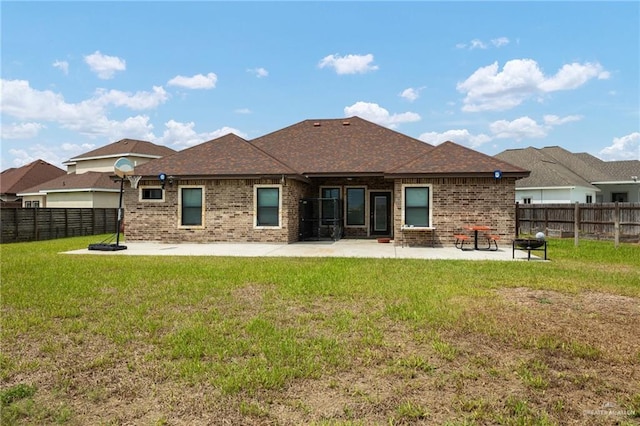 rear view of house with a yard and a patio