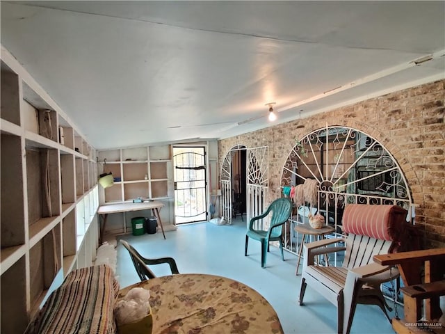 sitting room featuring concrete flooring and brick wall