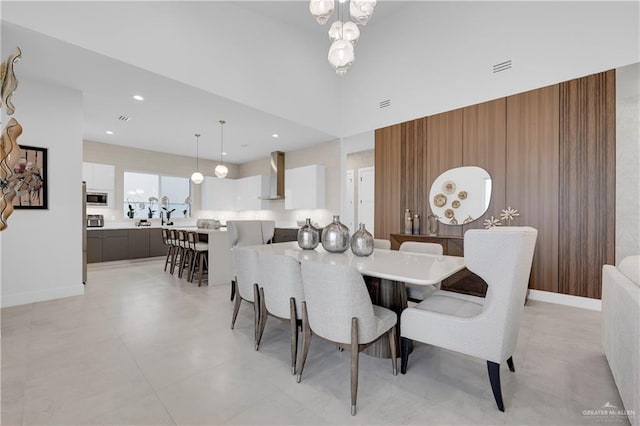 dining space featuring a high ceiling, recessed lighting, visible vents, and baseboards