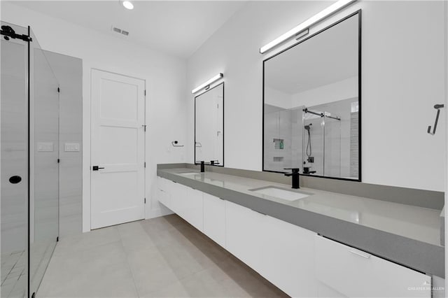 full bathroom with double vanity, a shower stall, visible vents, and a sink