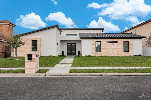 contemporary house featuring a front yard, a standing seam roof, metal roof, and stucco siding