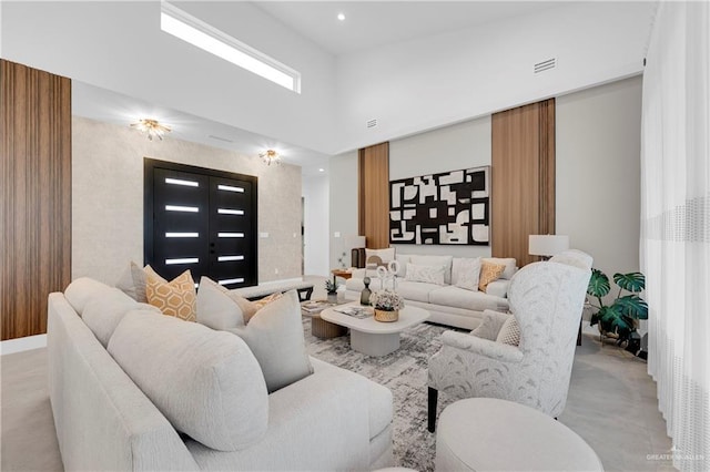 living area with a high ceiling, visible vents, and recessed lighting