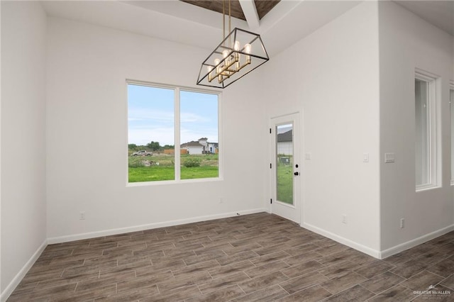 interior space with beam ceiling, dark hardwood / wood-style flooring, and a notable chandelier