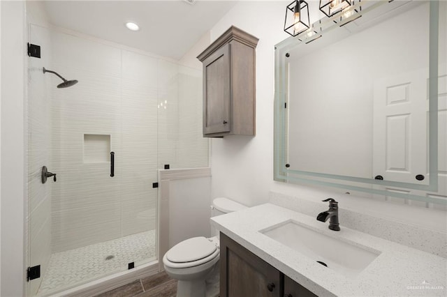 bathroom with hardwood / wood-style floors, vanity, toilet, and walk in shower