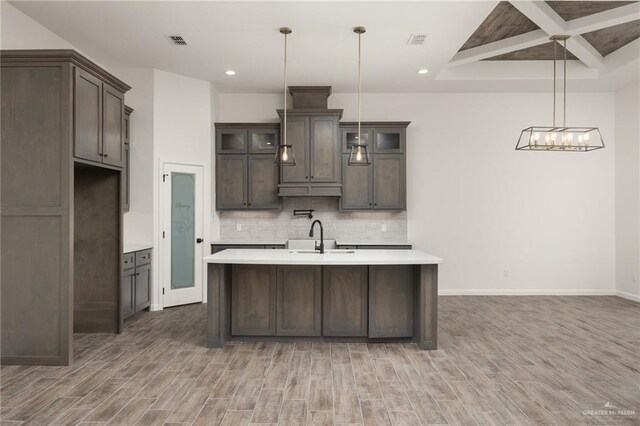 kitchen with pendant lighting, sink, hardwood / wood-style flooring, and tasteful backsplash