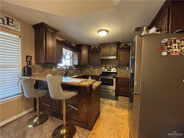 16400 Mcalister Ave, Edinburg, TX 78541 - kitchen featuring appliances with stainless steel finishes, a peninsula, decorative backsplash, and dark brown cabinets