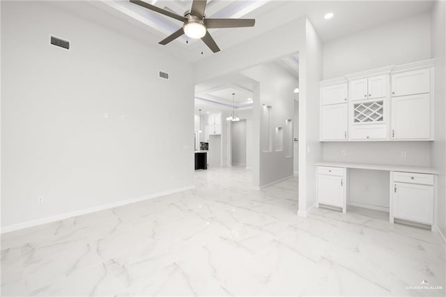 interior space featuring marble finish floor, visible vents, ceiling fan with notable chandelier, and baseboards