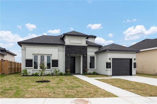 prairie-style house featuring driveway, stucco siding, a front yard, fence, and a garage