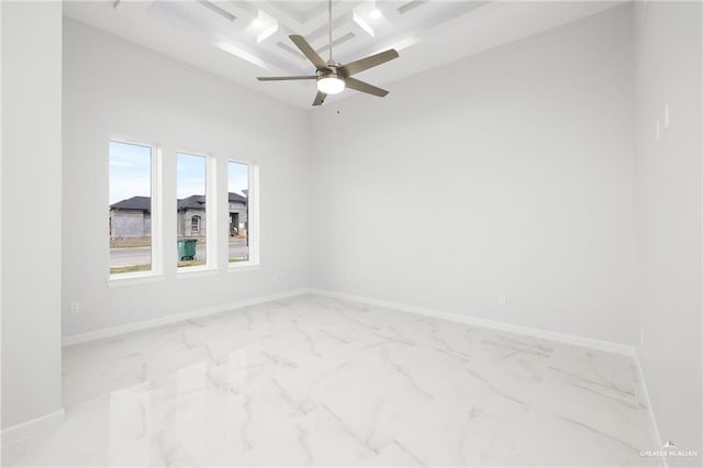 spare room featuring marble finish floor, ceiling fan, and baseboards