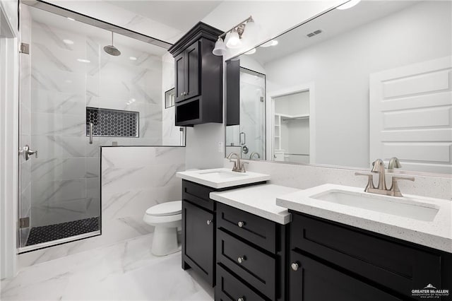 bathroom with marble finish floor, toilet, vanity, visible vents, and a marble finish shower