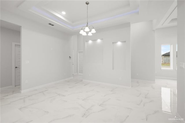 spare room featuring baseboards, visible vents, and a tray ceiling
