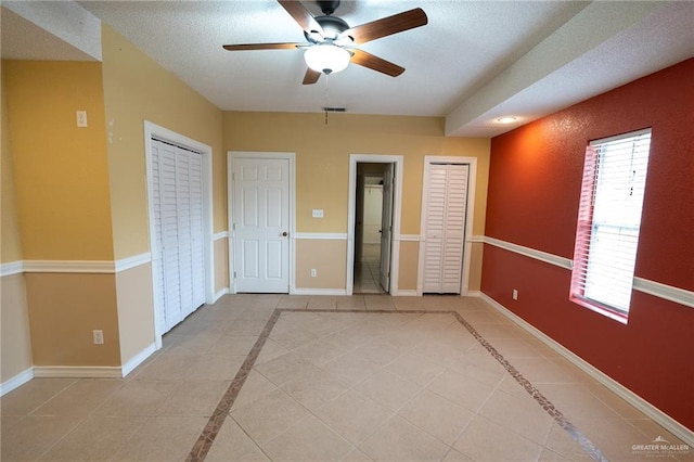 spare room featuring light tile patterned floors, a textured ceiling, and ceiling fan