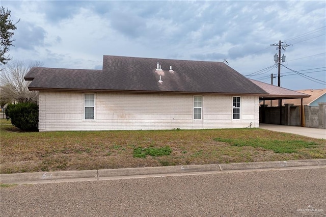 view of property exterior featuring a carport and a lawn