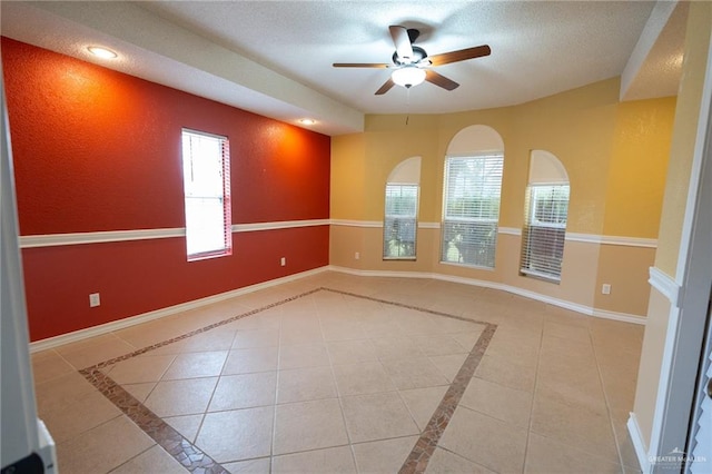 tiled spare room with ceiling fan and a textured ceiling