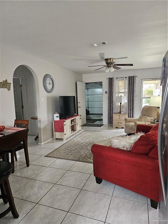 living room with ceiling fan and light tile patterned floors