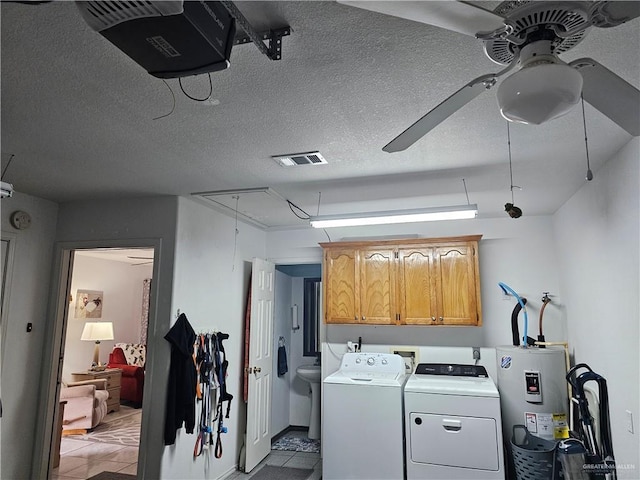 clothes washing area featuring ceiling fan, cabinets, electric water heater, a textured ceiling, and washing machine and clothes dryer