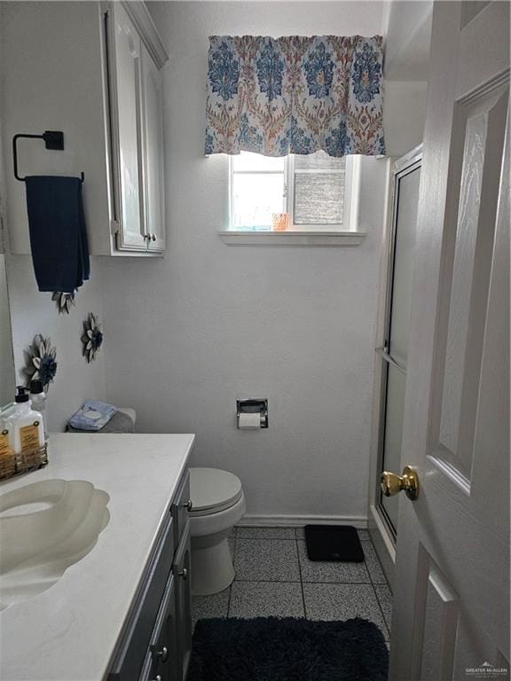 bathroom with vanity, toilet, and a shower with shower door