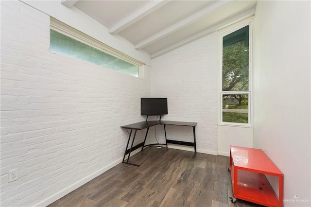 interior space featuring vaulted ceiling with beams, dark wood-type flooring, and brick wall