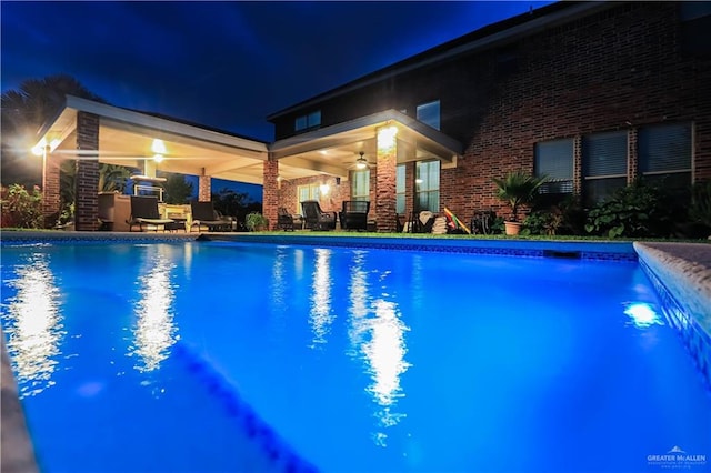 pool at night featuring ceiling fan