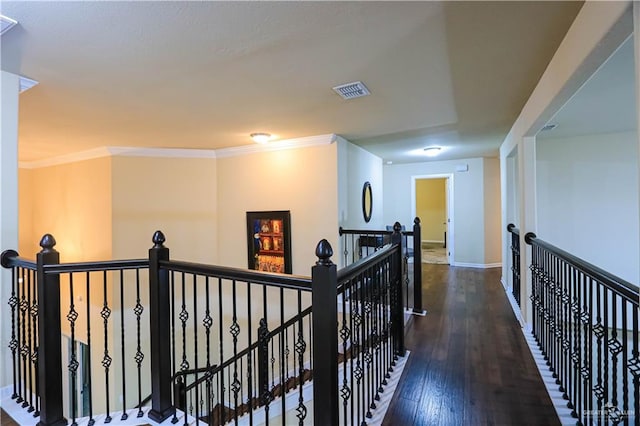 corridor with ornamental molding and dark wood-type flooring